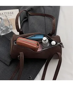 Spacious interior of dark coffee cylinder bag showing makeup and wallet storage