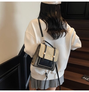 Detail of vintage beige and grey leather crossbody bag with gold buckle and logo