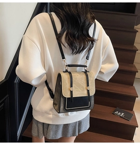 Detail of a two-tone beige and black versatile backpack with metal buckle accents