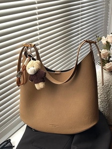 Sac hobo demi-lune en cuir marron avec breloque ours et large bandoulière réglable