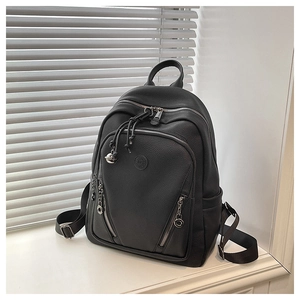Detail view of black lychee-textured leather backpack with multi-zipper compartments