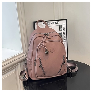 Detail of dusty rose PU leather backpack with silver bell charm and zipper pockets