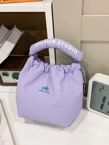 Fashionable purple nylon bucket tote bag with padded handles and minimalist aesthetic