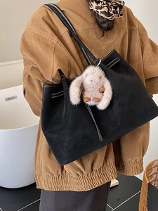 Retro black faux suede tote bag with white stitching and plush bunny charm on shoulder