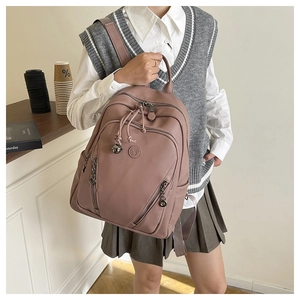 Close-up of dust pink faux leather backpack with litchi texture and metal zippers