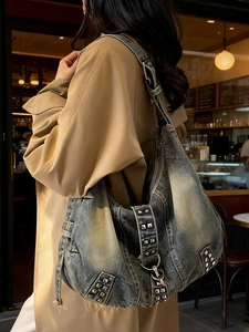 Vintage washed denim hobo bag with silver metallic studs shown in an urban setting