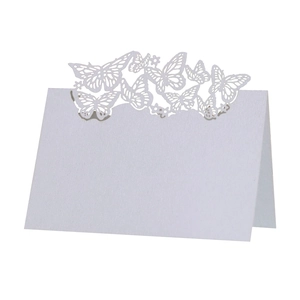 Macro shot of laser-cut butterfly detail on a white wedding place card made of cardstock