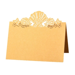 Laser-cut kraft paper place card with hollow starfish and seashell ocean theme design