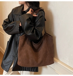 Brown suede tote bag on model showing large capacity and relaxed shoulder drop