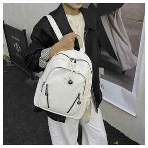 Detail of white litchi pattern backpack with round metal ball zipper pendant and side pockets