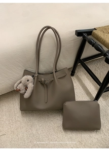 Close-up of khaki pebbled leather tote bag with matching pouch and plush bunny charm