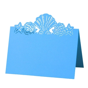 Light blue laser-cut place card with shell and starfish ocean theme for weddings