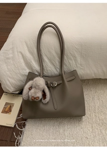 Close-up of retro large tote bag with lychee texture and cute plush rabbit charm