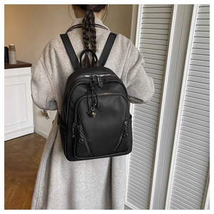 Rear view of black pebbled leather backpack with multiple zipper pockets on back