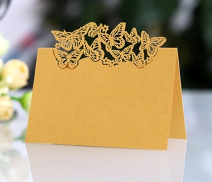 Detail of laser-cut gold butterfly place card with elegant pearlescent finish for weddings