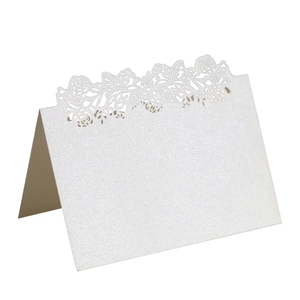 Detail of laser-cut hollow rose wedding place card with cream pearlescent finish