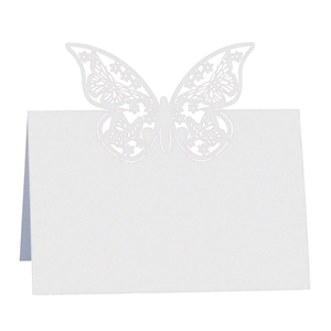 Detailed laser-cut butterfly design on white paper place card for wedding table setting