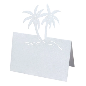 Detail of laser-cut white table card with intricate tropical palm tree design