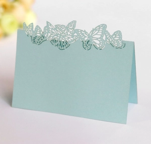 Detail showing laser-cut butterfly design on light blue place cards for wedding tables