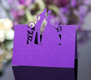Laser-cut purple wedding place cards with bride and groom silhouette on floral background