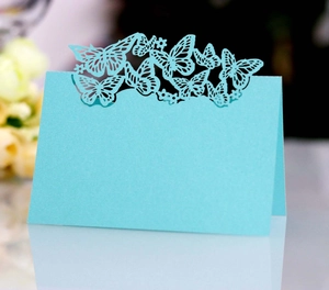 Detail of laser-cut butterfly hollow place card for weddings in elegant light blue finish