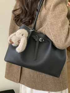 Minimalist black pebble leather tote bag with silver buckle and plush rabbit charm