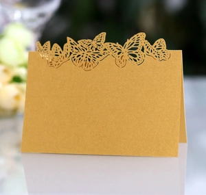 Detailed laser-cut butterfly place card in golden pearlescent paper for wedding decor