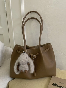 Brown litchi grain leather tote bag with long straps and a cute plush rabbit charm