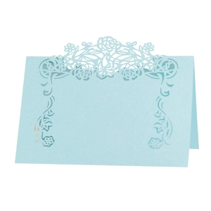 Detail of light blue laser-cut floral rose place card with elegant hollowed-out pattern