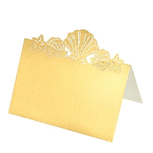 Detail of laser-cut gold place card with shell and starfish ocean theme patterns