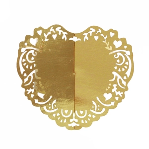 Macro detail of laser-cut gold heart napkin ring with intricate floral lace patterns