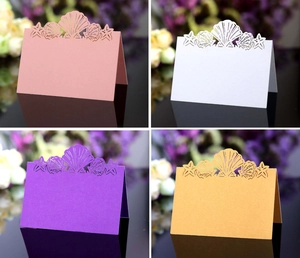 Detail of laser-cut ocean theme place cards with shells and starfish in pearlescent paper