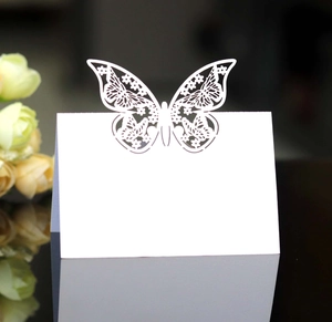 Close-up of laser-cut white butterfly place cards for wedding table seat arrangements