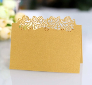 Close-up of golden laser-cut rose hollow place card with elegant floral details