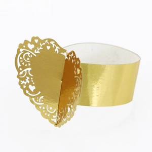 Macro view of golden laser-cut heart pattern and intricate scrollwork on napkin ring