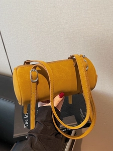Chic mustard yellow cylinder barrel bag with dual straps and smooth vintage leather texture