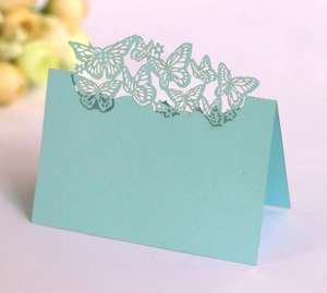 Macro shot of light blue laser-cut butterfly place card for wedding table settings