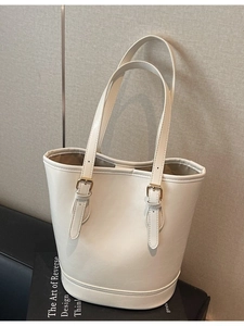 Elegant off-white faux leather bucket bag with adjustable handles and metal buckles