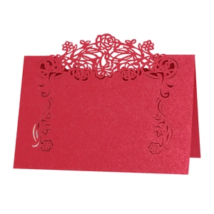Detail of red laser cut place card featuring intricate rose hollow patterns and glitter texture
