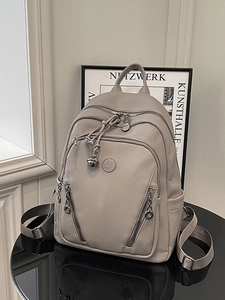 Elegant beige pebbled leather backpack with multiple zip pockets and adjustable straps