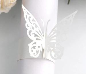 Macro shot of white laser-cut butterfly napkin ring with elegant pearl luster finish