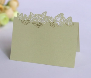Detail of laser-cut butterfly wedding place card in elegant light green pearlescent paper