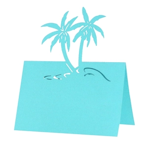Detail of light blue laser-cut palm tree place card for beach wedding table decor