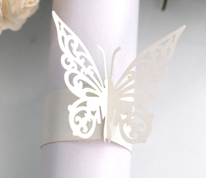 Detailed macro view of laser-cut butterfly napkin ring in pearlescent off-white paper