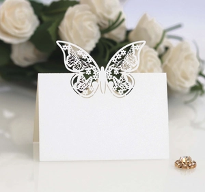 Detail of white laser-cut butterfly place card with pearl texture for wedding decor