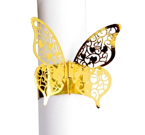 Macro view of gold laser-cut butterfly napkin ring with hollow heart patterns