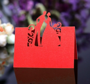 Detailed laser cut silhouette of bride and groom on a red wedding table place card