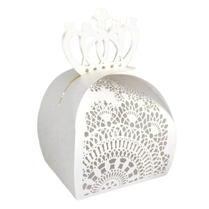 Detailed laser-cut white wedding favor box with an elegant crown lid and lace patterns