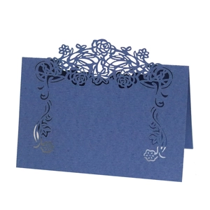 Detail of dark blue laser-cut rose floral lace on a freestanding pearl paper table card