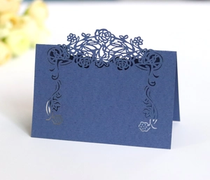 Detail view of navy blue laser-cut floral place card standing on a clean white desk